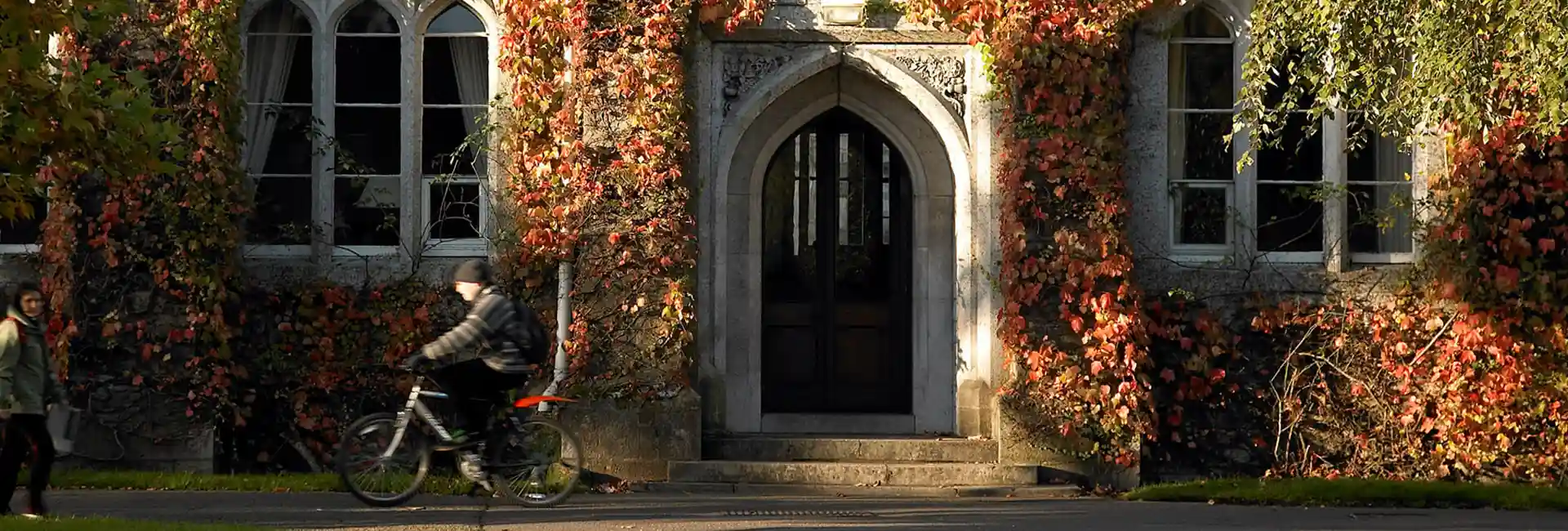 Autumn on UCC grounds, a cyclist passes the east wing entrance to the presidents wing