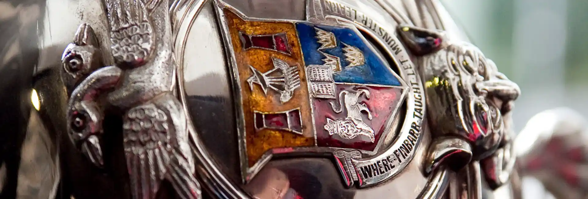 A close up of the UCC crest on the silver ceremonial mace