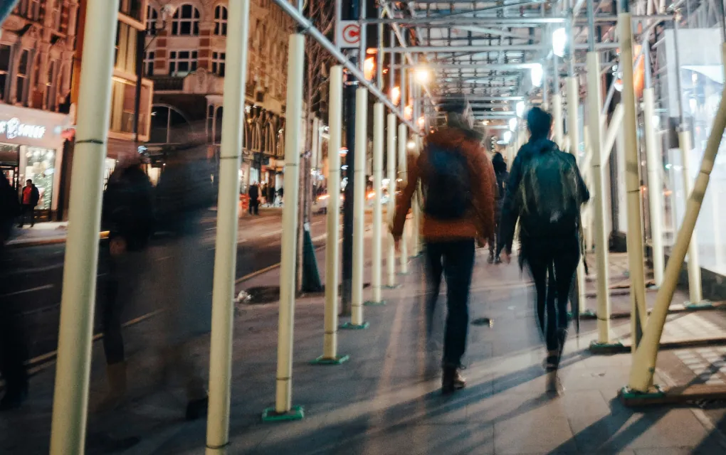People walking the streets of a busy city at night