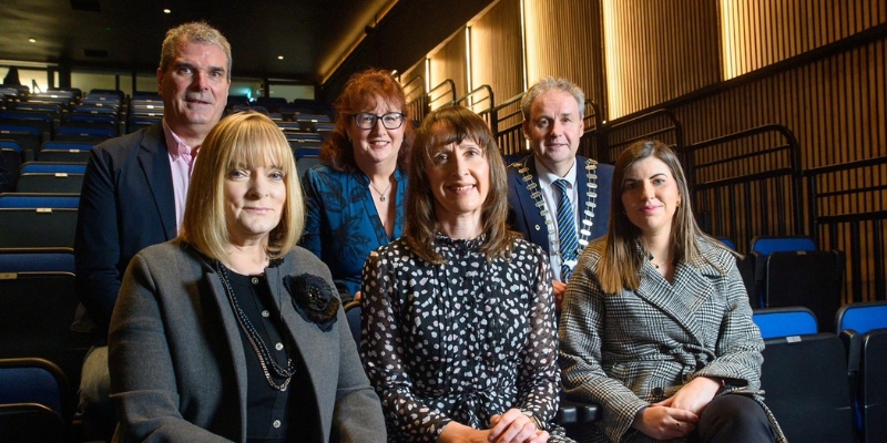 Close up of six people sitting in a theatre, three in the front seats and three in the seats behind them Close up of six people sitting in a theatre, three in the front seats and three in the seats behind them