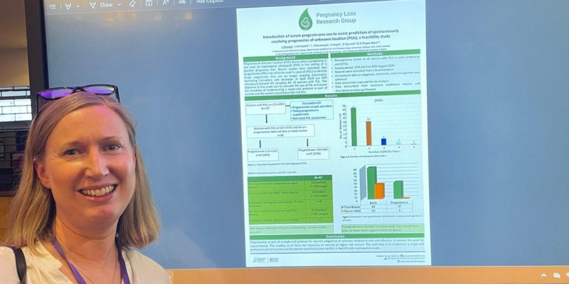 Woman standing beside an electronic conference poster Woman standing beside an electronic conference poster