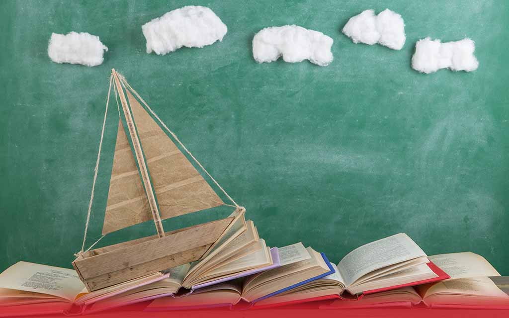 Child's toy ship sailing on open books, symbolising the journey to the future through knowledge