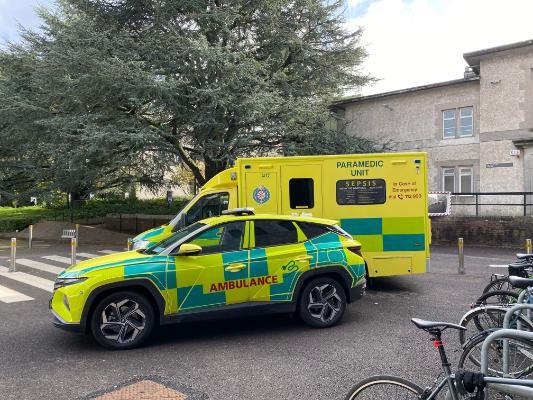 Yellow Ambulance and Yellow and Green responder car parked in the grounds of UCC against a backdrop of trees and pebble-dashed buildings. Yellow Ambulance and Yellow and Green responder car parked in the grounds of UCC against a backdrop of trees and pebble-dashed buildings.