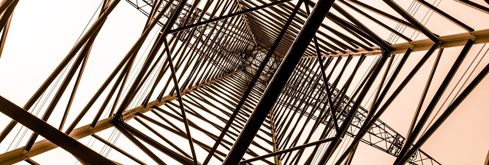 photo of the skeleton of a skyscraper against the sky looking up from the ground floor