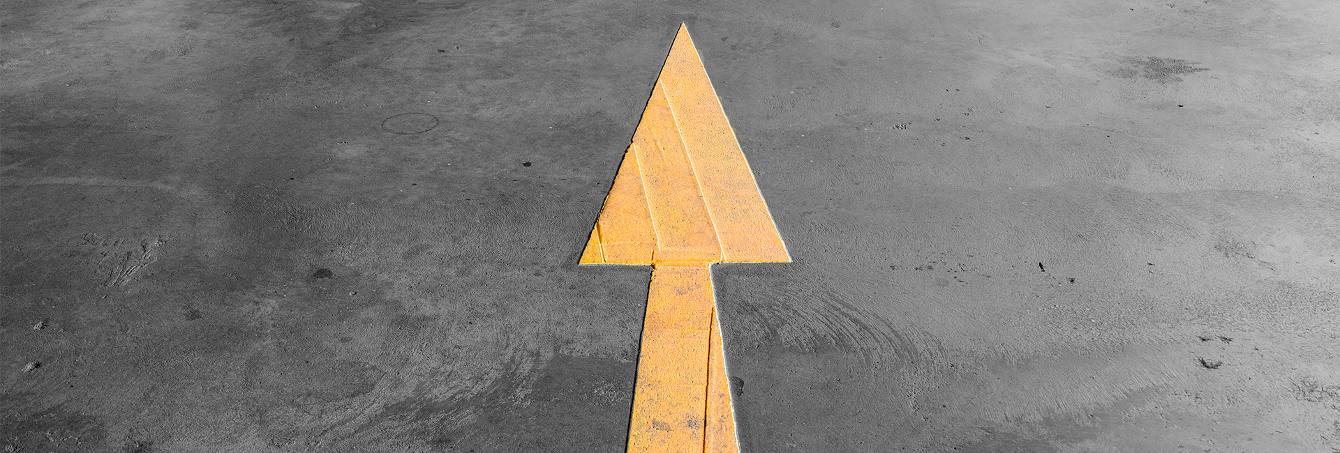 yellow arrow painted onto a dark grey road